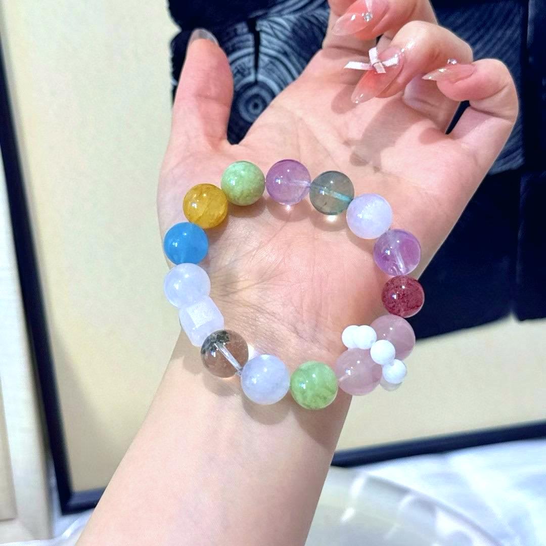 Multi-gemstone bracelet with rose quartz, amethyst, fluorite, yellow jade flower, green phantom quartz, aquamarine, and strawberry quartz, designed to enhance healing, emotional balance, and positive energy.