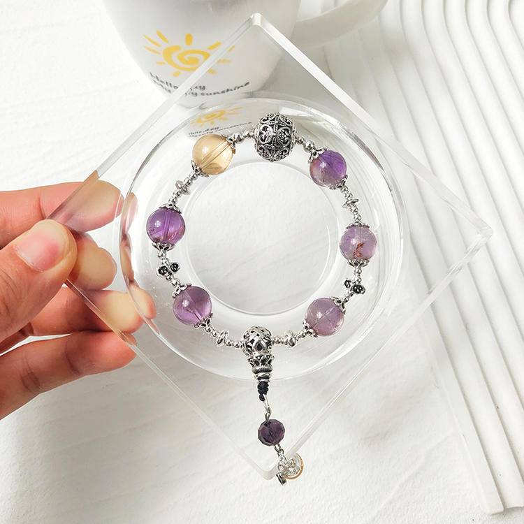 Healing bracelet featuring amethyst and citrine charms for energy, balance, and emotional well-being.
