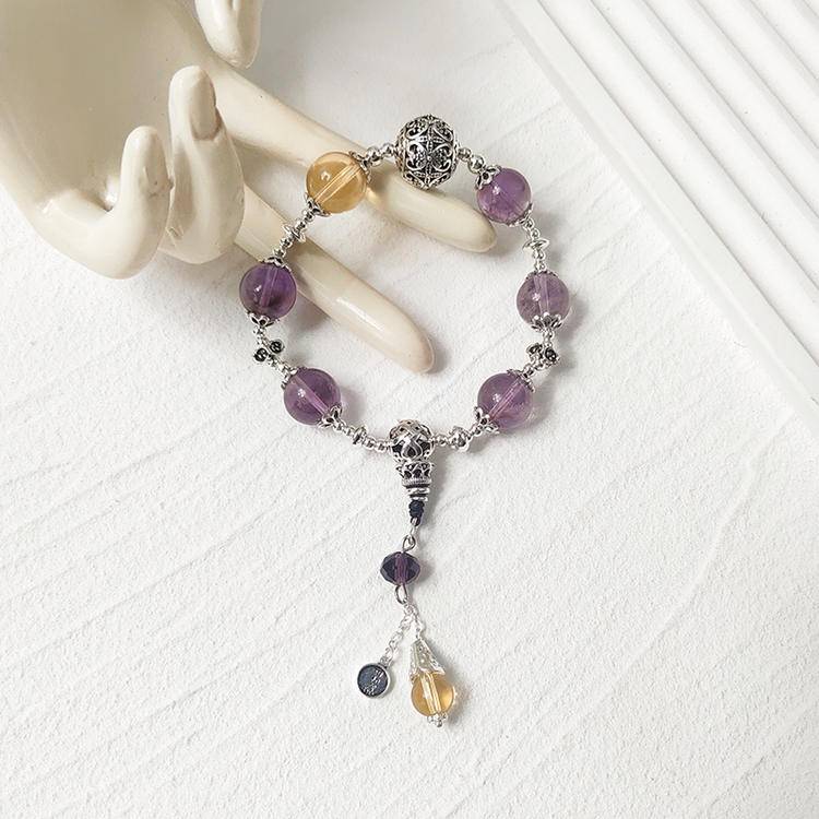 Amethyst and citrine charm bracelet supporting emotional balance, positive energy, and healing.

