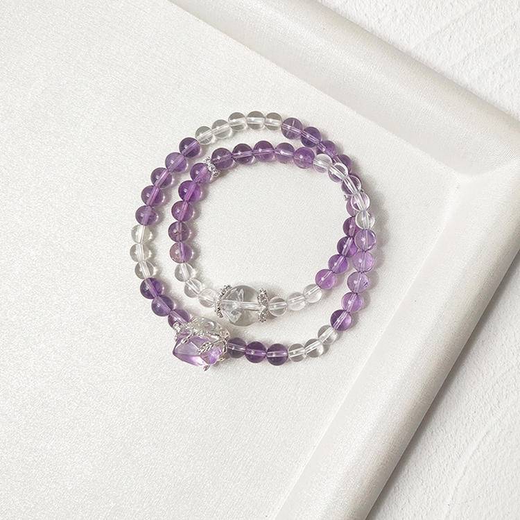 Amethyst and clear quartz double-strand bracelet supporting emotional balance, positive energy, and healing.
