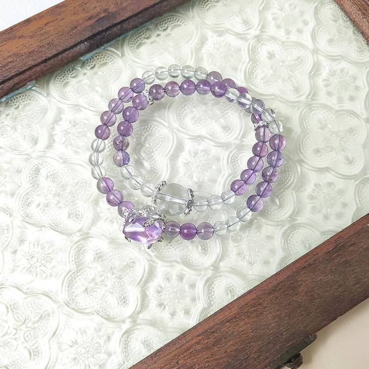Amethyst and clear quartz double-strand bracelet promoting healing, balance, and positive energy.
