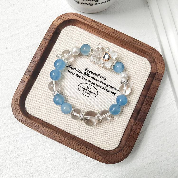 Aquamarine and bear charm bracelet promoting clarity, healing, and positive energy.