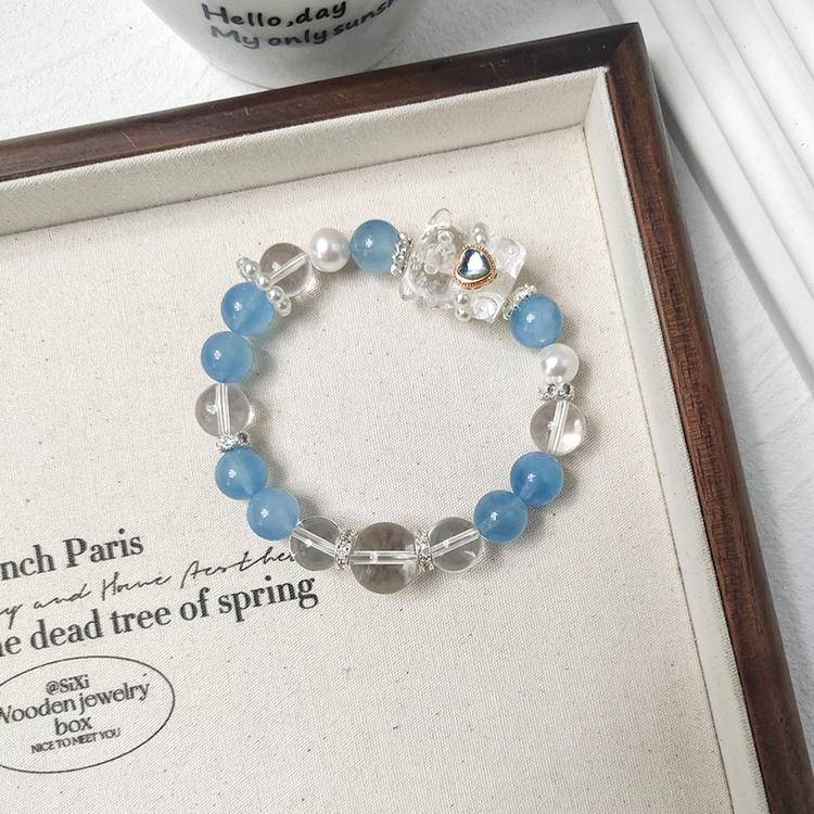 Healing multi-gem bracelet featuring aquamarine and bear charm for emotional balance and focus.