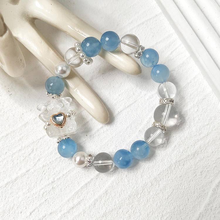 Aquamarine and bear charm bracelet supporting emotional well-being and positive intentions.
