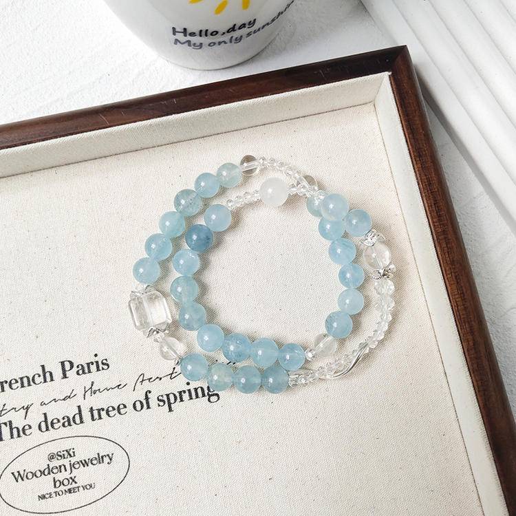 Aquamarine and clear quartz double-wrap bracelet promoting healing, balance, and positive energy.
