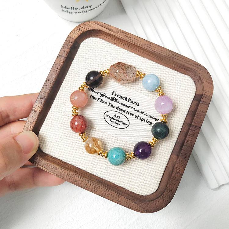 Black gold freeform multi-gemstone bracelet including citrine, amethyst, aquamarine, sunstone, lepidolite, smoky quartz, and red jade flower, supporting healing and emotional well-being.