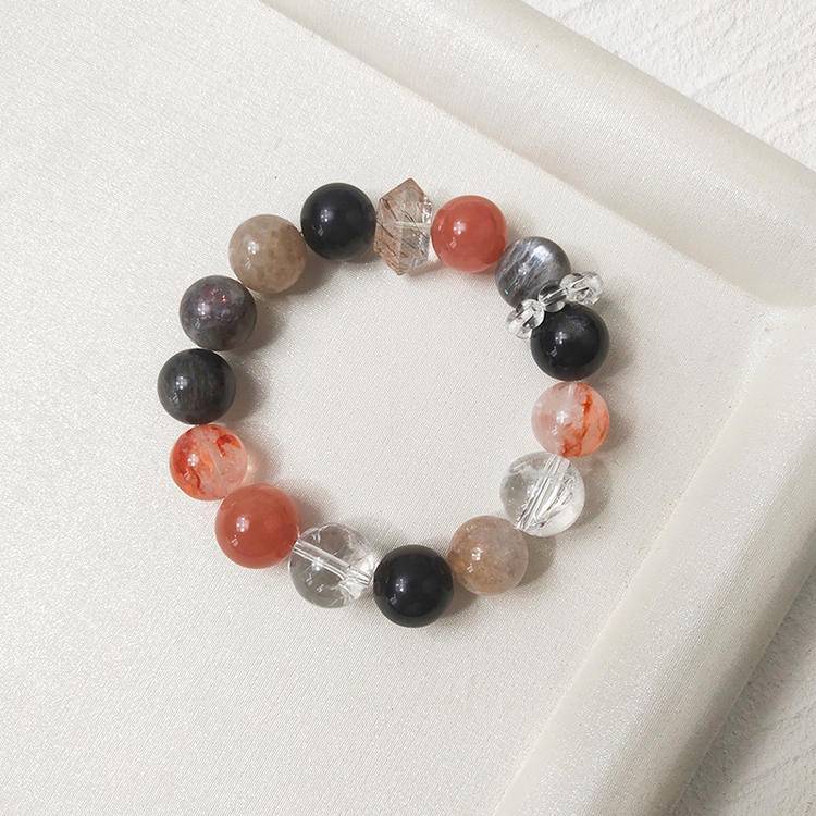 Healing multi-gemstone bracelet featuring black gold, skeleton stone, sunstone, clear quartz, obsidian, and red jade flower for emotional well-being and energy balance.
