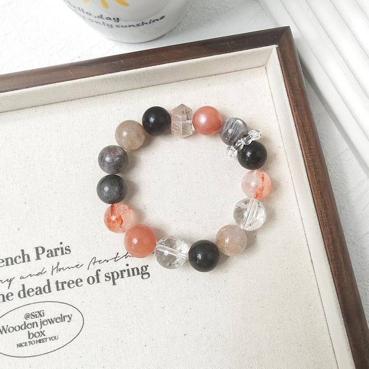 Black gold skeleton sunstone multi-gemstone bracelet with clear quartz, obsidian, and red jade flower, promoting healing, positive energy, and balance.
