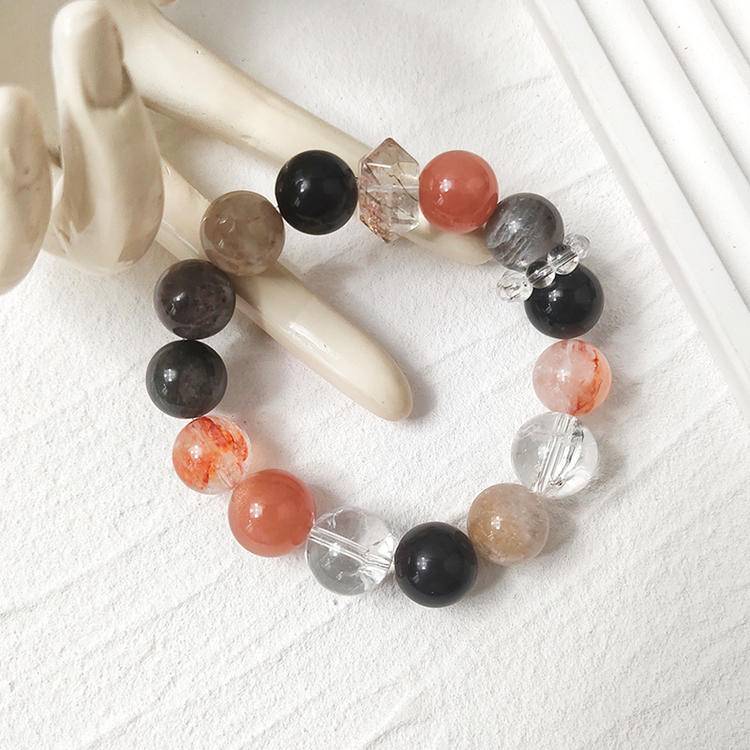Multi-gemstone bracelet with black gold, skeleton stone, sunstone, clear quartz, obsidian, and red jade flower, designed to enhance healing, balance, and positive energy.
