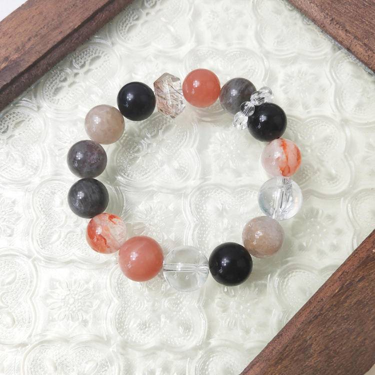 Black gold skeleton sunstone bracelet with clear quartz, obsidian, and red jade flower, supporting emotional balance, energy, and healing.
