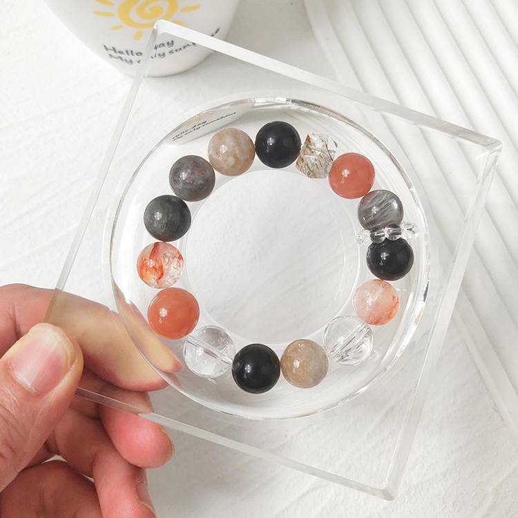 Healing bracelet featuring black gold, skeleton stone, sunstone, clear quartz, obsidian, and red jade flower, promoting positive energy and emotional well-being.
