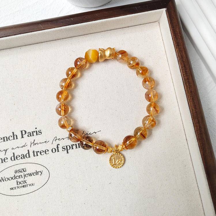 Healing multi-gem bracelet featuring citrine and lucky cat charm for wealth, balance, and focus.