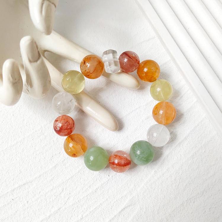 Healing bracelet featuring citrine, yellow jade flower, fluorite, red jade flower, snow phantom quartz, and clear quartz for energy, balance, and emotional well-being.
