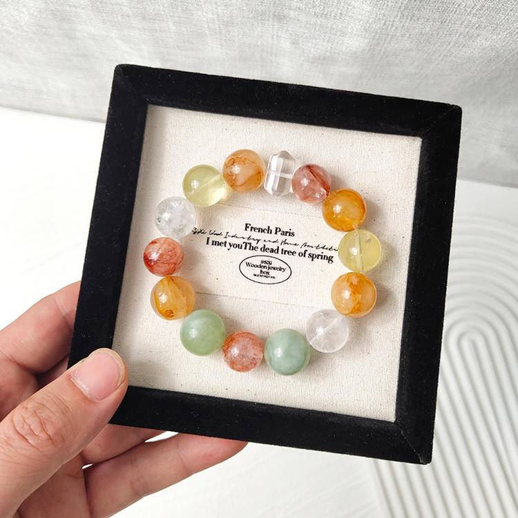 Multi-gemstone bracelet with citrine, yellow jade flower, fluorite, red jade flower, snow phantom quartz, and clear quartz, designed to enhance healing, positive energy, and balance.
