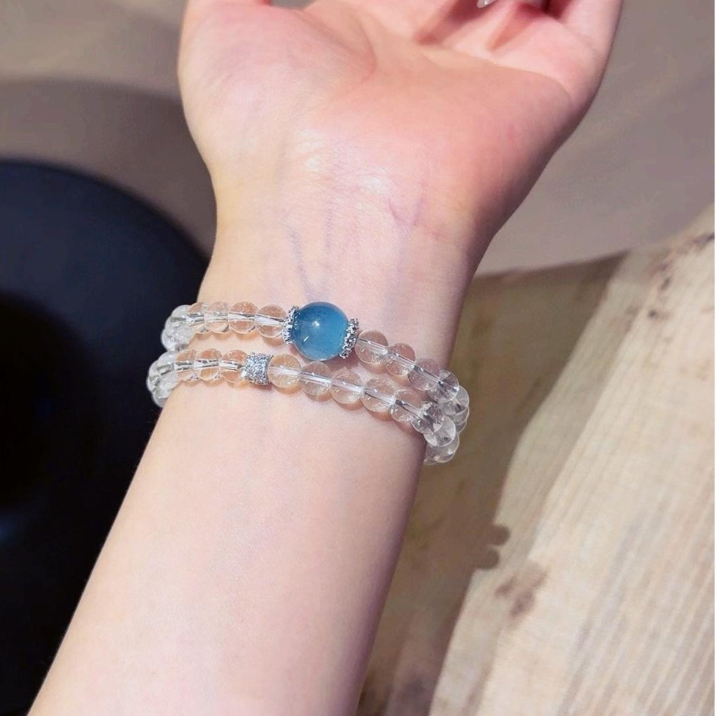Healing multi-layer bracelet featuring clear quartz and aquamarine for emotional well-being and energy balance.
