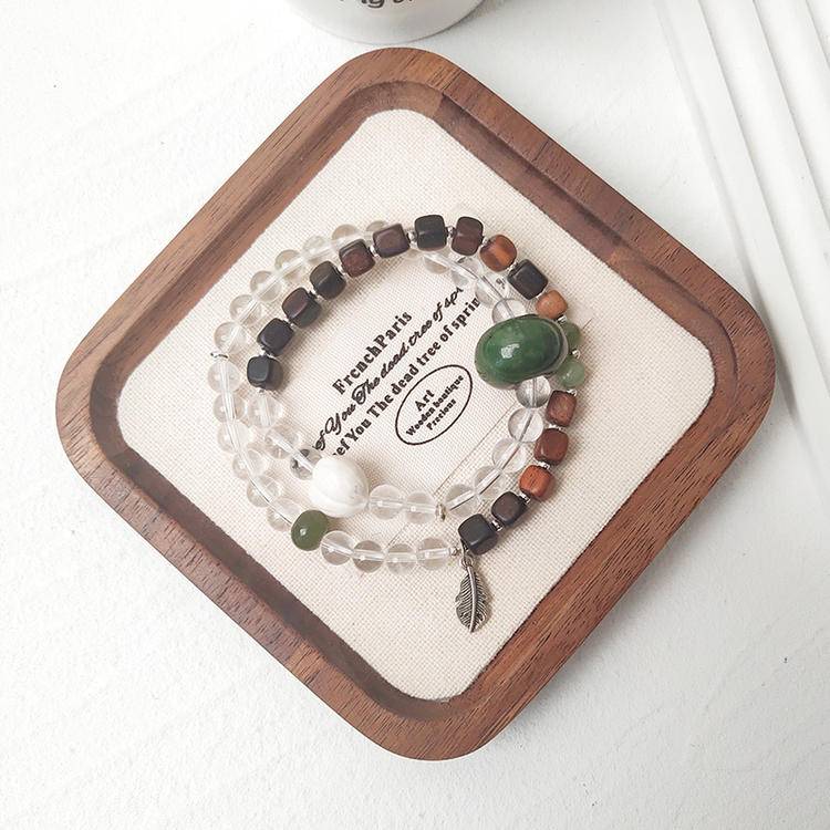 Clear quartz, jade, and agarwood double wrap bracelet promoting healing, balance, and positive energy.
