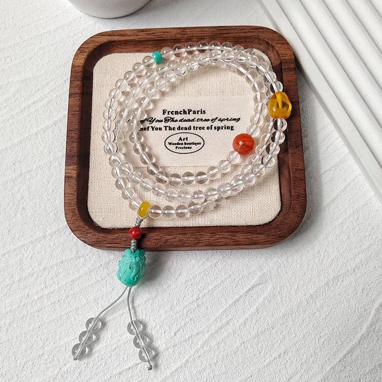Clear quartz 108-bead mala with turquoise pixiu promoting meditation, protection, and positive energy.
