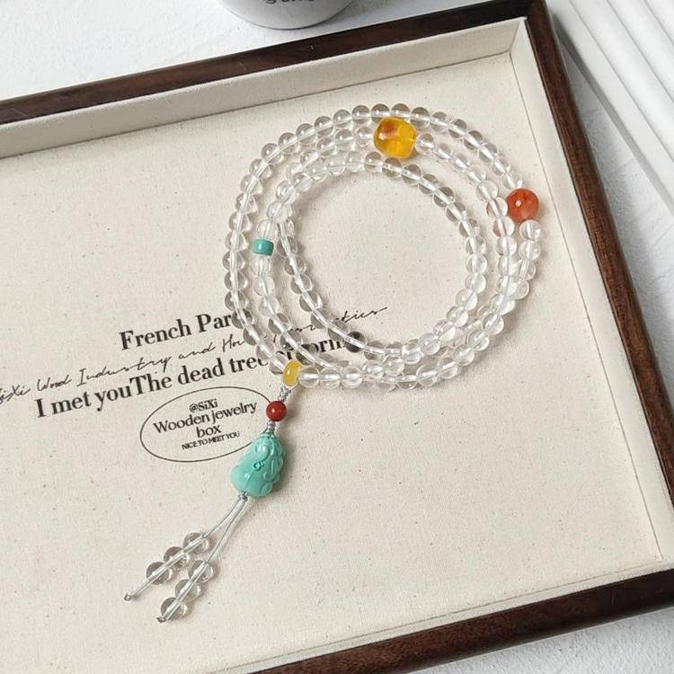 108-bead mala with clear quartz and turquoise pixiu designed to promote meditation, healing, and spiritual protection.
