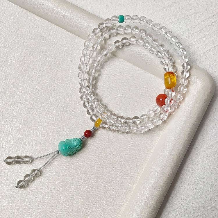 Clear quartz 108-bead mala with turquoise pixiu supporting mindfulness, energy balance, and spiritual protection.
