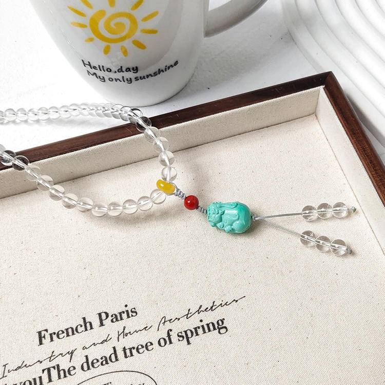 Healing 108-bead mala featuring clear quartz and turquoise pixiu for meditation, energy balance, and spiritual protection.
