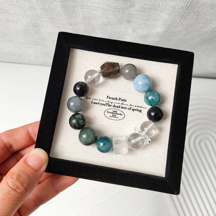 Healing multi-gemstone bracelet featuring green dragon quartz, green rutilated quartz, aquamarine, gray rabbit hair quartz, blue crystal stone, clear quartz, and black rutilated quartz for emotional well-being and energy balance.
