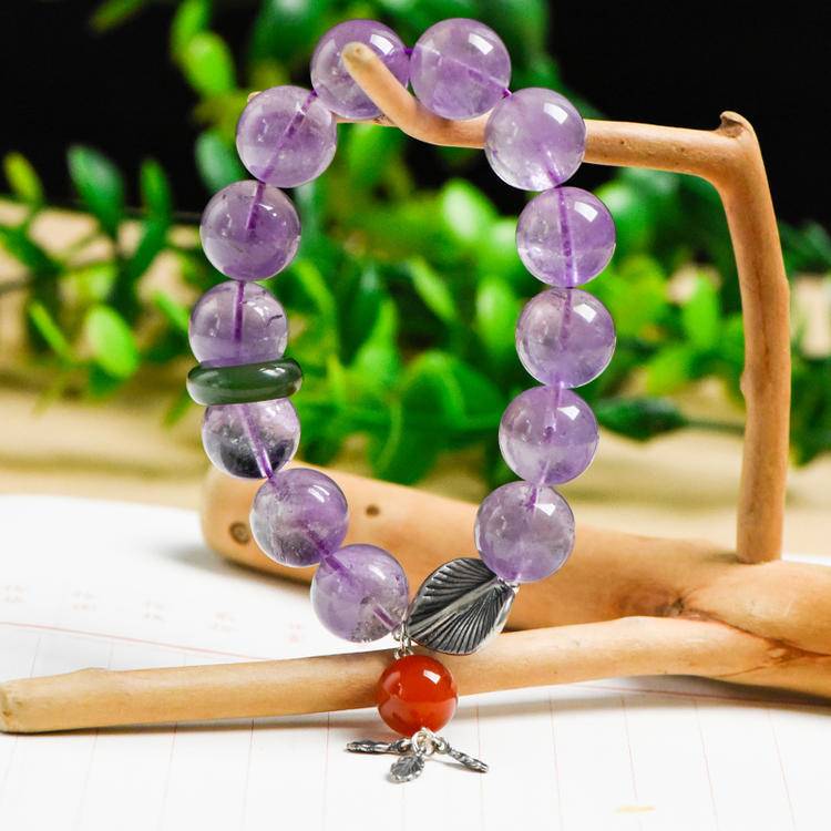 Lavender amethyst, jade, and gingko leaf multi-gemstone bracelet promoting healing, balance, and positive energy.

