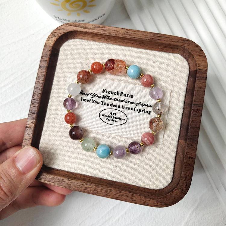 Multi-gemstone bracelet with red jade flower, pixiu, black gold crystal, amethyst, rhodonite, agate, clear phantom quartz, gold sunstone, lepidolite, and prehnite, designed to enhance healing, positive energy, and protection.
