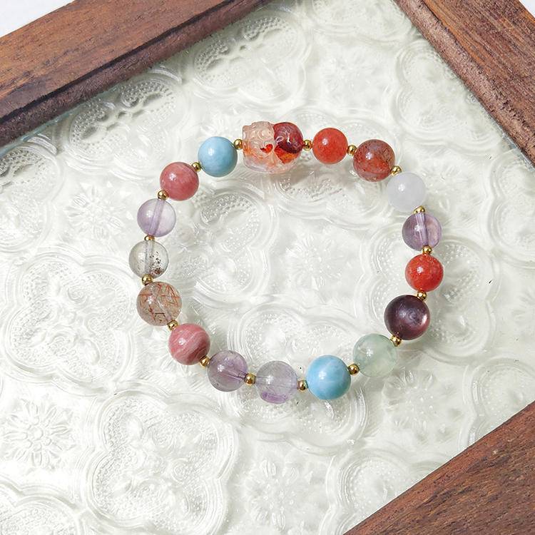 Red jade flower and pixiu bracelet with black gold crystal, amethyst, rhodonite, agate, clear phantom quartz, gold sunstone, lepidolite, and prehnite, promoting emotional well-being, protection, and energy balance.
