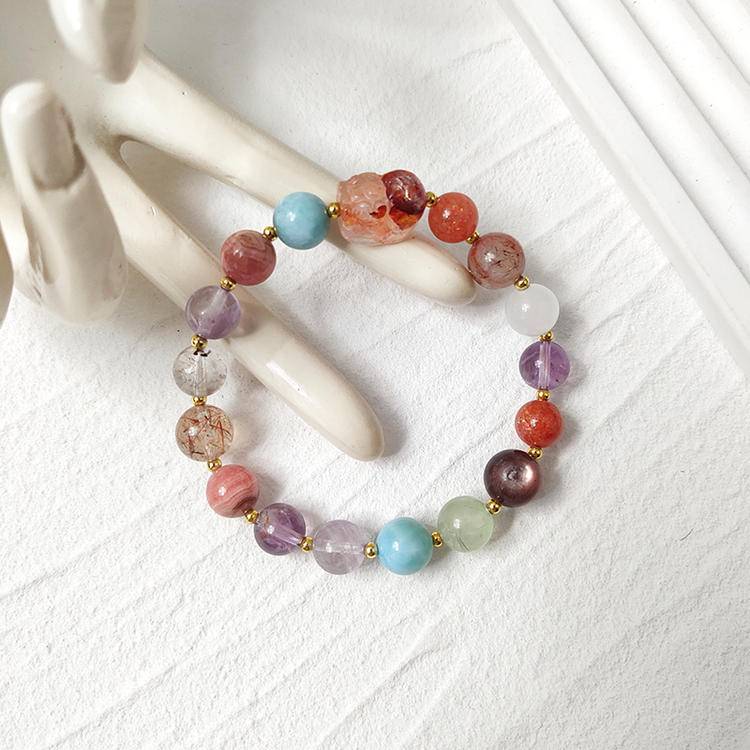 Healing bracelet featuring red jade flower and pixiu charm with black gold crystal, amethyst, rhodonite, agate, clear phantom quartz, gold sunstone, lepidolite, and prehnite for positive energy and balance.
