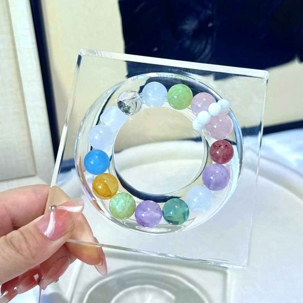 Healing multi-gemstone bracelet featuring rose quartz, amethyst, fluorite, yellow jade flower, green phantom quartz, aquamarine, and strawberry quartz for energy balance and well-being.
