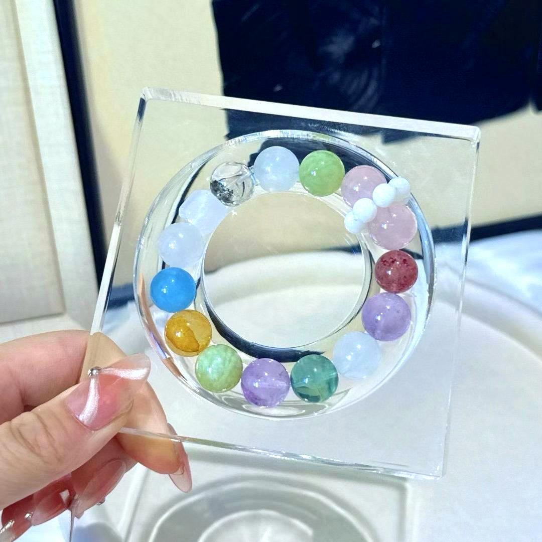 Healing multi-gemstone bracelet featuring rose quartz, amethyst, fluorite, yellow jade flower, green phantom quartz, aquamarine, and strawberry quartz for energy balance and well-being.
