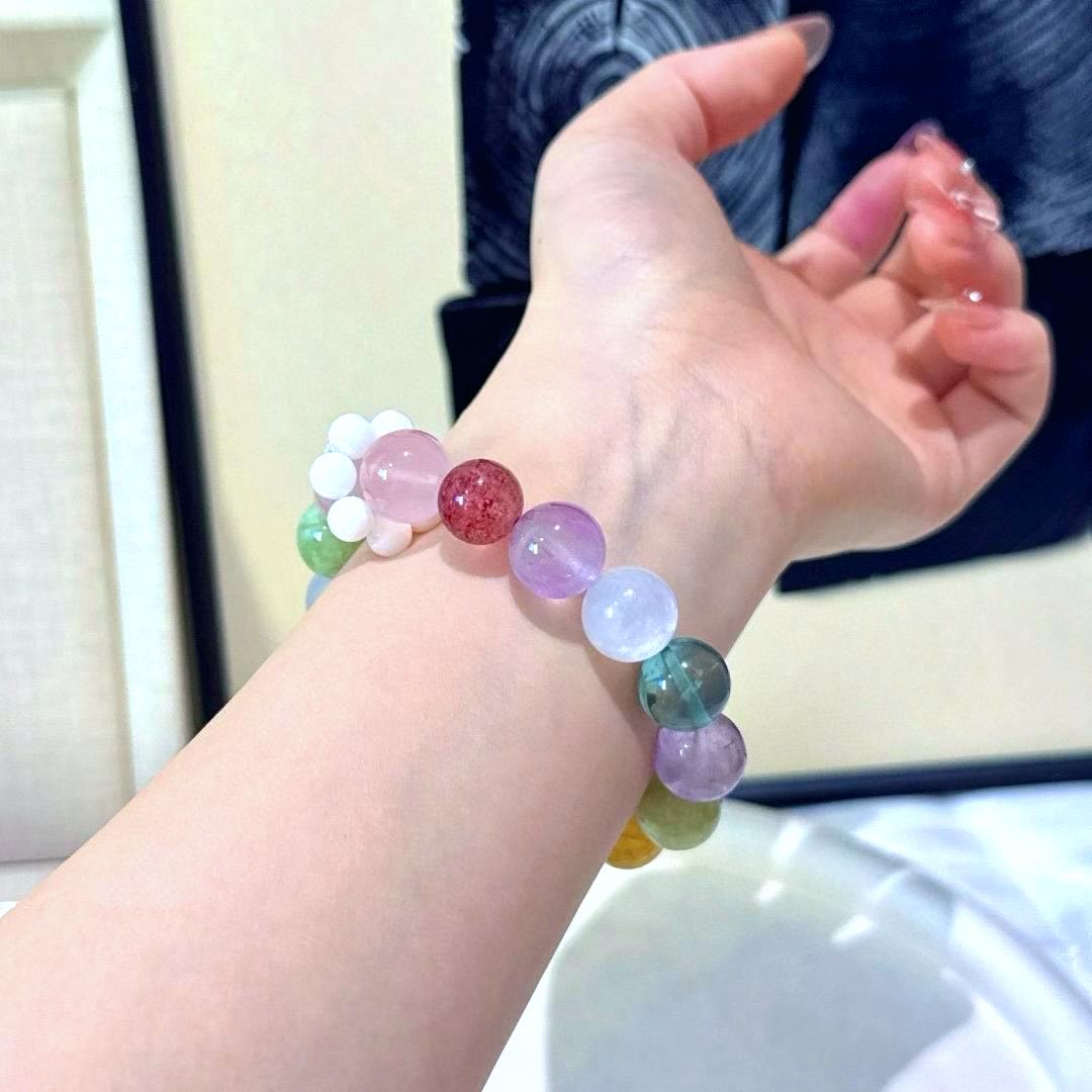 Rose quartz and amethyst bracelet with fluorite, yellow jade flower, green phantom quartz, aquamarine, and strawberry quartz, promoting healing, balance, and positive energy.
