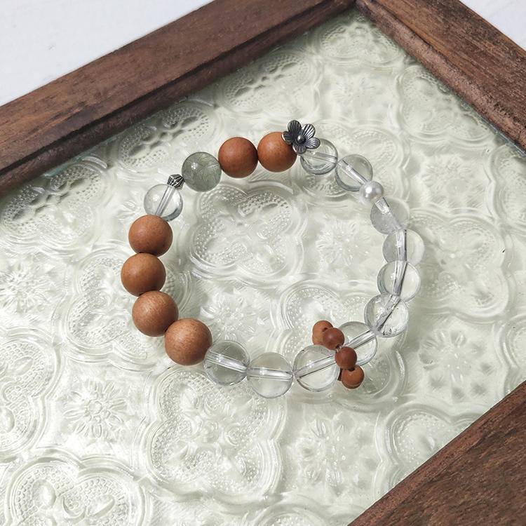 Multi-gem bracelet with sandalwood, green rutilated quartz, and clear quartz, designed to enhance healing, balance, and positive energy.
