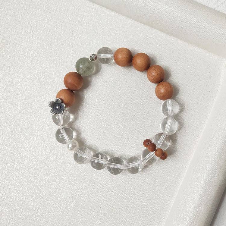 Healing multi-gemstone bracelet featuring sandalwood, green rutilated quartz, and clear quartz for emotional well-being and energy balance.
