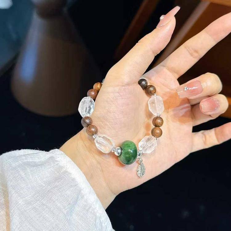 Healing multi-gemstone bracelet featuring sandalwood, jade, and clear quartz for emotional well-being and energy balance.
