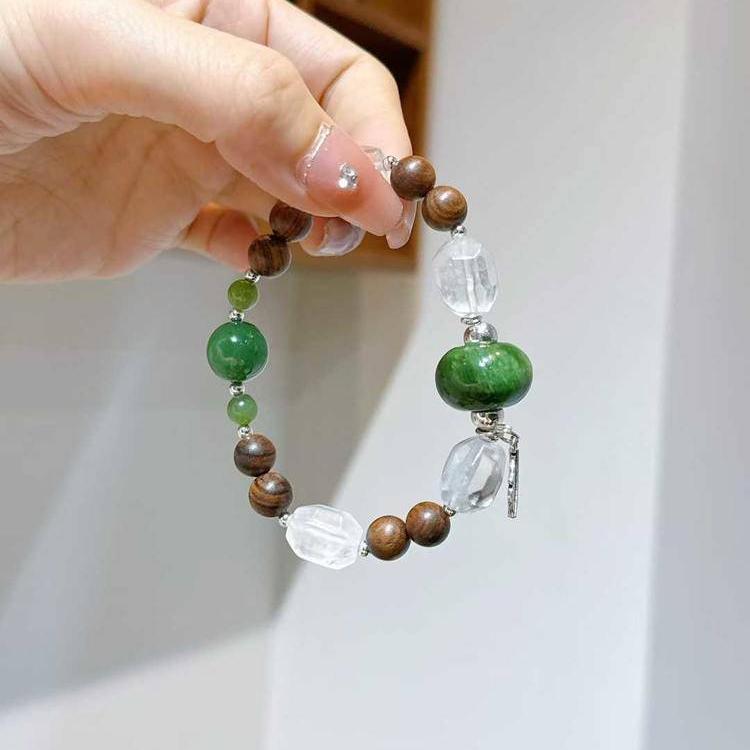 Sandalwood, jade, and clear quartz multi-gemstone bracelet designed to promote healing, balance, and positive energy.
