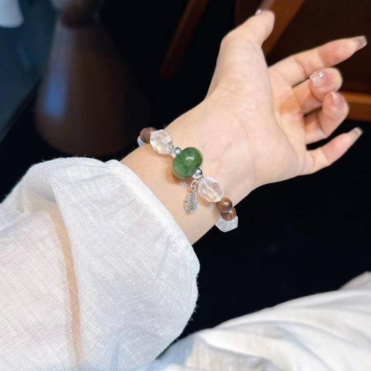 Sandalwood, jade, and clear quartz multi-gemstone bracelet promoting healing, balance, and positive energy.
