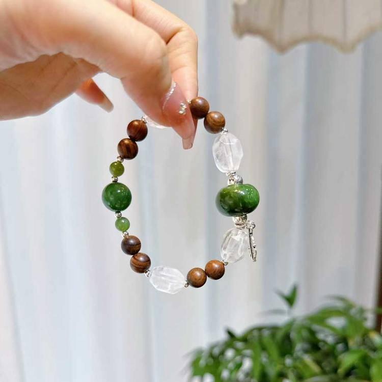 Sandalwood, jade, and clear quartz bracelet supporting emotional balance, positive energy, and healing.
