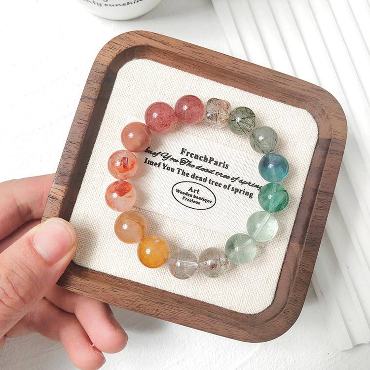 Multi-gemstone bracelet with strawberry quartz, green stones, red and yellow jade flowers, sunstone, black gold crystal, and fluorite, designed to enhance healing, energy, and emotional health.
