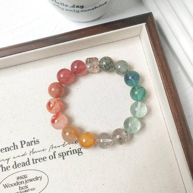 Strawberry quartz and green multi-gemstone bracelet with red jade flower, yellow jade flower, fluorite, green phantom quartz, sunstone, and black gold crystal, promoting healing, positive energy, and emotional balance.
