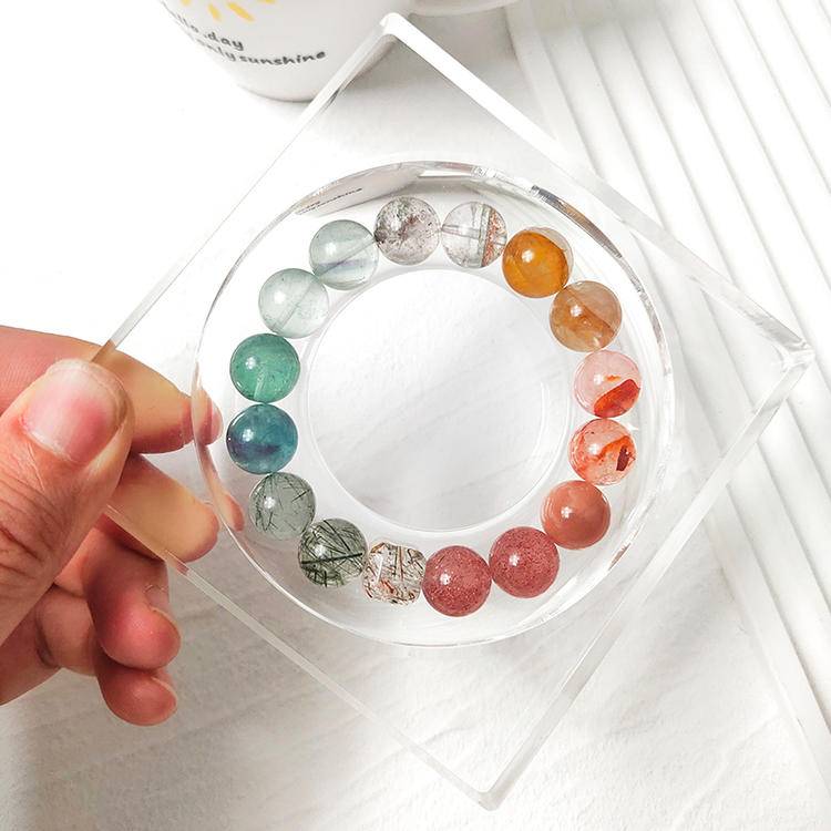 Strawberry quartz and green multi-gemstone bracelet featuring sunstone, black gold crystal, fluorite, and red and yellow jade flowers for healing, balance, and emotional well-being.
