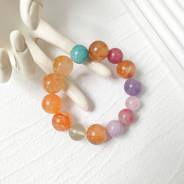 Multi-gemstone bracelet with yellow jade flower, citrine, aquamarine, rhodochrosite, and lepidolite crystals, enhancing healing and well-being.
